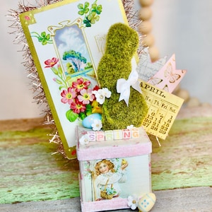 Ancienne carte postale de Pâques, printemps, avec un lapin topiaire assis sur un fond doux décoré d'images printanières.