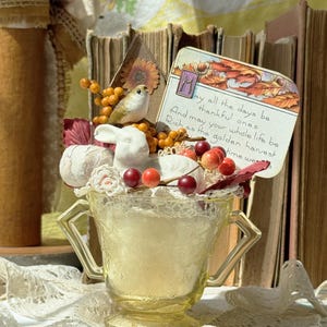 Açucareiro vintage de vidro amarelo com depressão, cheio de um doce coelho de porcelana e uma mensagem de outono de um cartão postal antigo.