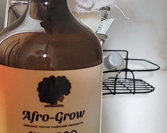 May include: A brown bottle of Afro-Grow shampoo with a black pump top. The label is white with green and yellow accents. The text on the label reads "Afro-Grow Organic Vegan Haircare Products Shampoo Biotin Thickening for Women Men and Children Hair Ginger and Aloe Vera Based Formula Net Wt. 16 oz."