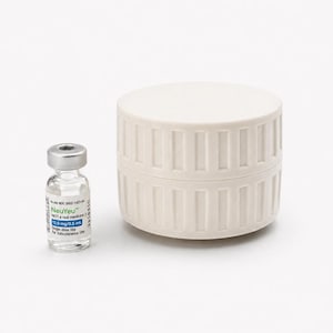 May include: A small glass vial with a silver cap and a white and blue label next to a cream-colored, cylindrical container. The vial contains a clear liquid and the label reads "NeuYeu" and other medical information.