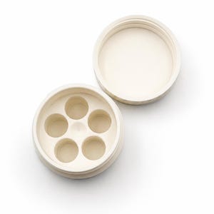May include: Off-white, circular container with a lid, revealing five small, evenly spaced compartments. The lid is separate, showing the interior. The container is made of a smooth, matte material, likely ceramic or a similar substance.