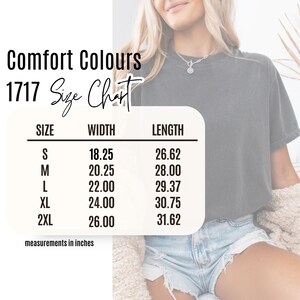 May include: A size chart for Comfort Colours 1717 t-shirts. The chart displays measurements in inches for sizes S to 2XL. Widths range from 18.25 to 26 inches, and lengths range from 26.62 to 31.62 inches. The chart is on a white background.