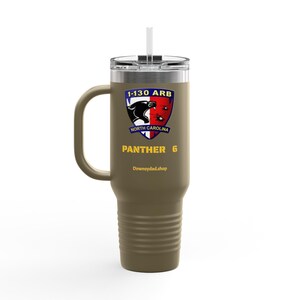 May include: A green travel mug with a black handle and a lid. The mug has a graphic of a black panther with the text "1-130 ARB NORTH CAROLINA PANTHER 6" and "Downysdad.shop".