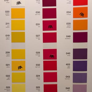 May include: Color swatches arranged in vertical columns, showcasing a range of hues from yellow to red and purple. Each swatch is labeled with a number and color name, with some including the letters "RA". The image is a color chart.