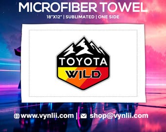May include: White microfiber towel, 18" x 12", with a colorful Toyota Wild logo featuring a mountain design. The towel is sublimated on one side. Website and email address are printed at the bottom.