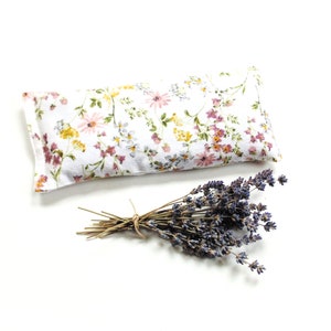 Organic lavender eye pillow made of soft flannel and has pretty flowers on a white background. Filled with flaxseed, rice, and lavender. Can be heated in microwave or kept in freezer. Use for cold or warm therapy.