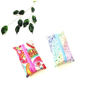 May include: Two rectangular fabric tissue holders. One features a vibrant red, yellow, and green paisley pattern with a bright pink center strip. The other displays a multicolored polka dot design with a light blue center strip.