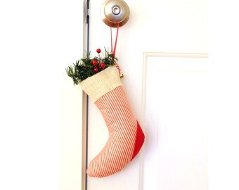 One hanging Christmas stocking, holiday decoration, faux greenery and red berries