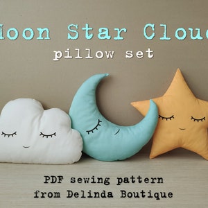 Peut inclure: Un ensemble de trois coussins en peluche en forme de lune, d'étoile et de nuage. La lune est bleu clair, l'étoile est jaune et le nuage est blanc. Chaque coussin a un visage souriant avec les yeux fermés. Le texte "Moon Star Cloud pillow set" est au-dessus des coussins. Le texte "PDF sewing pattern from Delinda Boutique" est en dessous des coussins.
