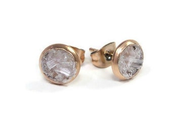 May include: A pair of gold stud earrings with clear, faceted gemstones.