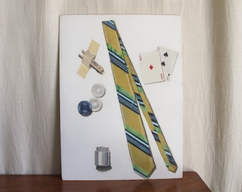 Tromp l'oeil oil on board painting, artist signed Rob Candor, gentlemanly accessories: necktie, poker chips, lighter, c. 1950