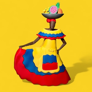 May include: A woman wearing a yellow, blue, and red dress with a ruffled neckline and a skirt that resembles the Colombian flag. She is carrying a basket of fruit on her head, including a watermelon, bananas, and pineapple.