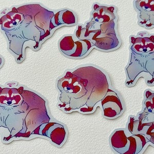 May include: A set of nine colorful raccoon stickers with a holographic finish. The raccoons are depicted in various poses, including sitting, standing, and walking. The stickers are perfect for adding a touch of whimsy to laptops, water bottles, journals, and more.