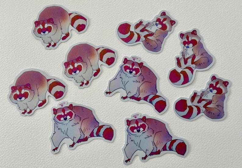 May include: Nine colorful raccoon stickers with pink, white, and gray fur. The raccoons are in various poses, including sitting, lying down, and standing. The stickers are perfect for adding a touch of whimsy to laptops, water bottles, or journals.