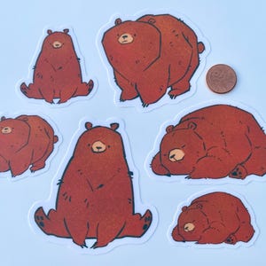 photograph showing the size difference between 2 inch and 3 inch stickers with a penny for scale