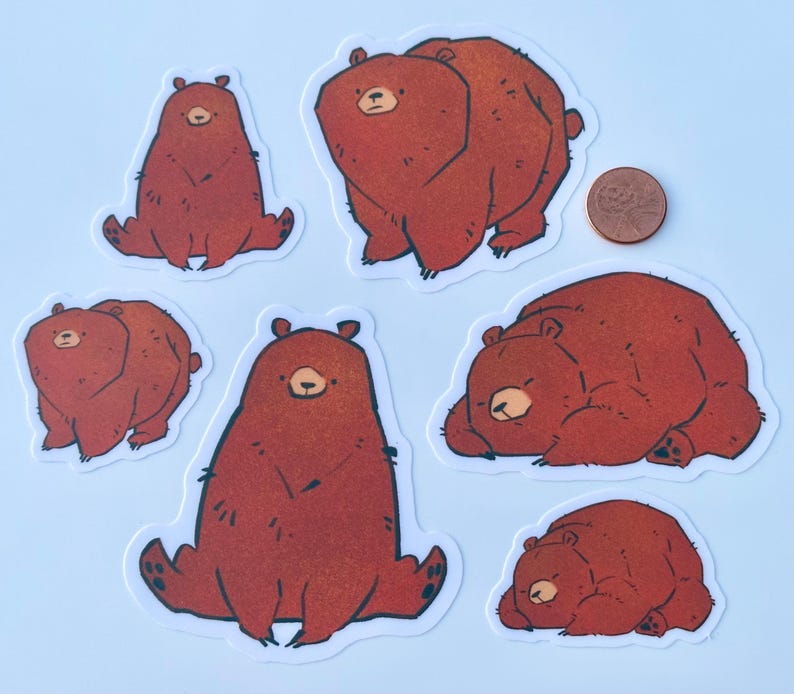 photograph showing the size difference between 2 inch and 3 inch stickers with a penny for scale