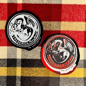 May include: Two circular patches with a dragon design. One patch is black and white, the other has red accents. Both patches feature the text "Frederick, Maryland" and "the small yaster".