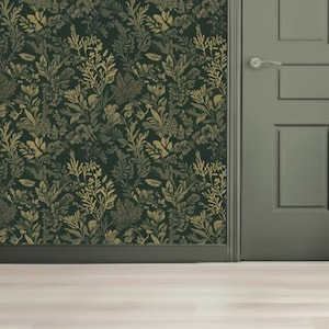 Puede incluir: Papel pintado verde oscuro con un patrón repetitivo de elementos botánicos dorados y verde oliva. El diseño presenta hojas y flores estilizadas. Se ve una sección de una puerta verde con un tirador plateado.