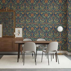 Könnte beinhalten: Ein Esszimmer mit einem dunklen Holztisch und vier hellgrauen Stühlen. Die Tapete ist dunkelblau mit einem floralen Muster in Orange, Grün und Braun. Ein großer Spiegel und Kunstwerke befinden sich an der Wand.