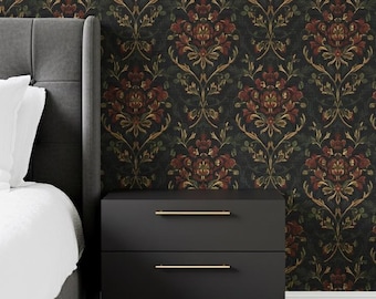 May include: A bedroom scene featuring a dark floral wallpaper with red and gold accents. A black nightstand with two drawers and gold handles sits below the wallpaper. A gray bed frame and white bedding are visible on the left.