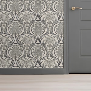 May include: Floral wallpaper in grey and off-white, featuring a repeating pattern of stylized flowers and leaves. A grey door with a gold handle is visible. The skirting board is grey, and the floor is light-coloured.