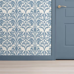 May include: A section of a room featuring wallpaper with a repeating blue floral pattern against an off-white background. A blue door and trim are visible, along with a gold door handle and light-colored wood flooring.