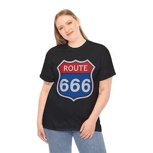 May include: Black t-shirt with a Route 666 sign graphic. The sign is shield-shaped, with a red top section reading "ROUTE", and a blue bottom section with the number "666" in white. The shirt is worn by a person.