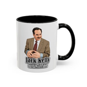 May include: White ceramic mug with a black interior and handle. The mug features an illustration of a man in a suit with the text "Jack Kelly Attorney at Large with BIG MASCULINE hands."