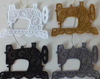 May include: Four decorative sewing machine ornaments in white, gold, black, and gray. Each ornament is made of lace and features intricate scrollwork. They are suspended by thin gold or silver cords, suitable for hanging.