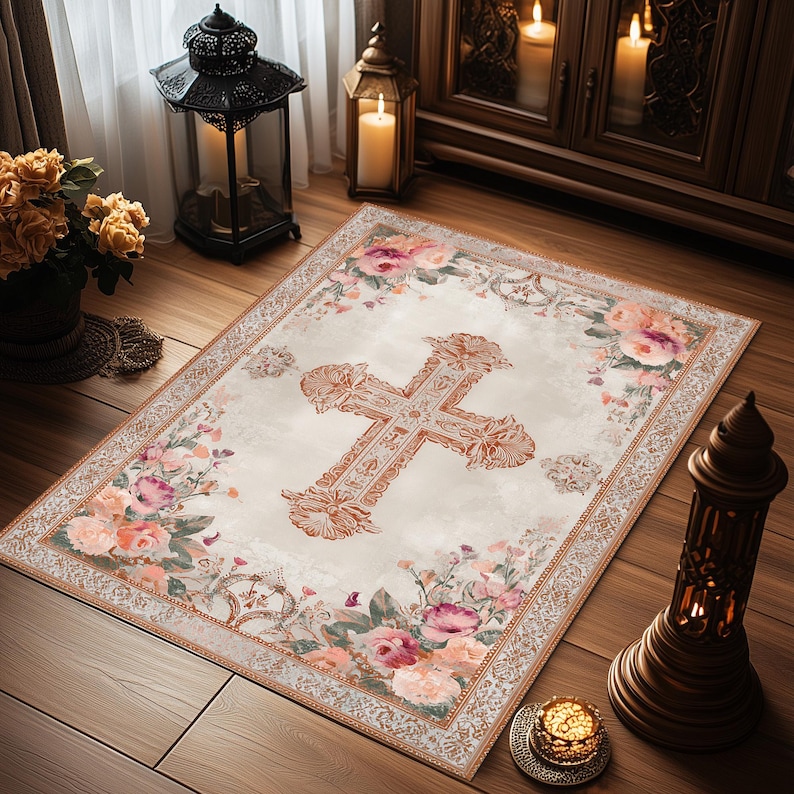 Puede incluir: Una alfombra rectangular con fondo crema y un gran dise&ntilde;o de cruz ornamentada en el centro. La alfombra est&aacute; bordeada con motivos florales en tonos rosa, melocot&oacute;n y verde. Las dimensiones de la alfombra son de aproximadamente 152 cm por 102 cm.