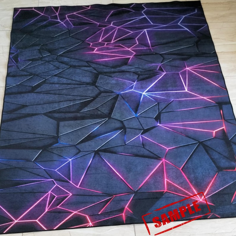 Puede incluir: Una alfombra rectangular grande con un dise&ntilde;o geom&eacute;trico. La alfombra presenta un fondo azul oscuro con un patr&oacute;n de formas angulares interconectadas. L&iacute;neas rosas y azules brillantes resaltan los bordes de las formas, creando un efecto 3D. La palabra "SAMPLE" est&aacute; estampada en la parte inferior derecha.