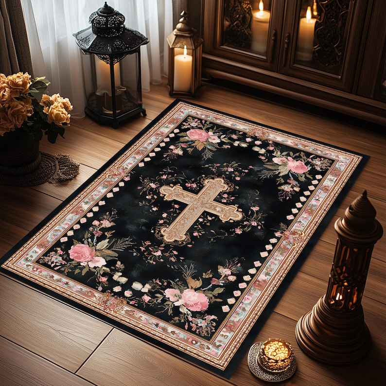 May include: A rectangular black rug with a floral and cross design. The rug features a large, ornate cross in the center, surrounded by pink roses and other flowers. The border is a mix of cream, pink, and brown. The rug is placed on a wooden floor.