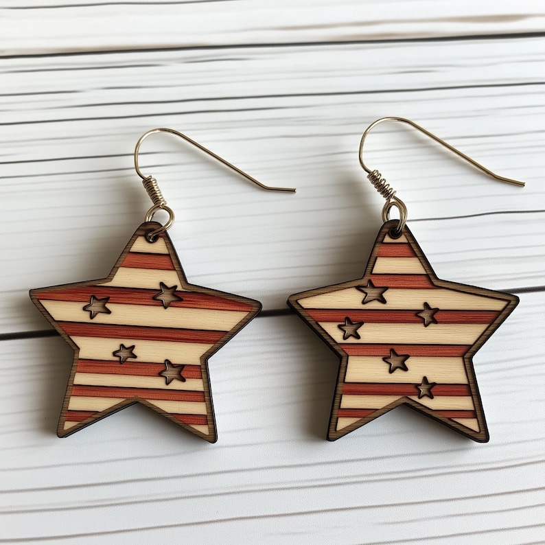 Op de afbeelding: Een paar houten stervormige oorbellen met een rood-wit gestreept patroon en kleine witte sterren. De oorbellen hebben zilveren haakjes.