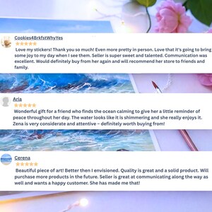 May include: A digital display of three customer reviews for an art shop, each featuring a five-star rating. The reviews are overlaid on a painting of blue ocean waves crashing against a rocky shore, accompanied by a thin paintbrush and pink flowers.