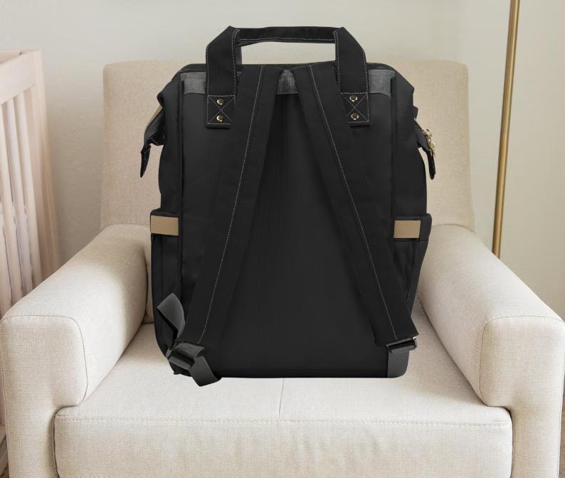 Pu&ograve; includere: Zaino nero per pannolini con spalline regolabili e dettagli beige. Lo zaino ha una chiusura con cerniera e diverse tasche.