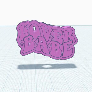 May include: A pink 3D printed charm with the text "Lover Babe" in a retro font. The charm has a glittery effect and is perfect for adding a touch of personality to your jewelry or keychain.