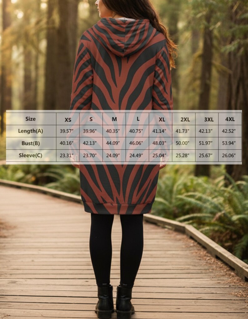 Peut inclure: Robe &agrave; capuche avec un motif &agrave; rayures z&eacute;br&eacute;es marron et noir. La robe arrive au genou et a des manches longues. L'image comprend un tableau des tailles avec des mesures en centim&egrave;tres pour la longueur, le buste et les manches.