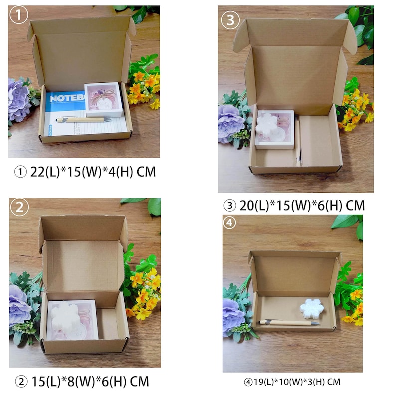 May include: Four open cardboard boxes of varying sizes, each containing stationery items. The boxes are surrounded by floral arrangements. Box 1 measures 22cm x 15cm x 4cm and contains a notebook and pen. Boxes 2, 3, and 4 also contain stationery.