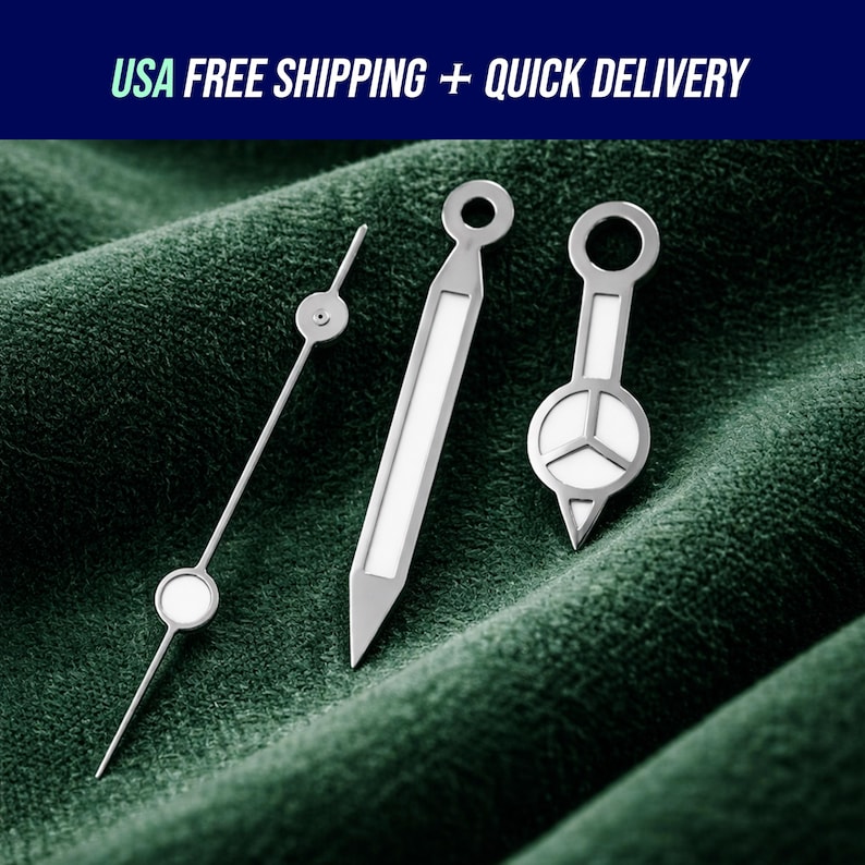 May include: Three silver watch hands with white accents are displayed against a dark green textured background. The hands vary in shape, including a long, thin hand with a circular end, and two wider hands with geometric designs. The text "USA FREE SHIPPING + QUICK DELIVERY" is at the top.