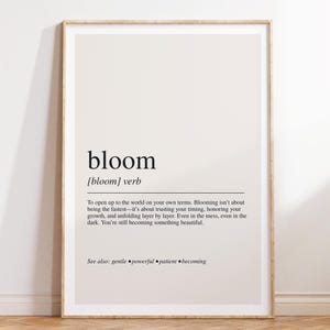The image is a framed print with a definition of the word "bloom" and a message encouraging the viewer to embrace their own growth and beauty.