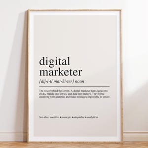Könnte beinhalten: Ein gerahmter Wandkunstdruck mit einer wörterbuchartigen Definition des Begriffs digital marketer. Der Text ist in Schwarz auf hellbeigem Hintergrund gedruckt und enthält die phonetische Aussprache, ein Substantiv und einen Beschreibungstext.