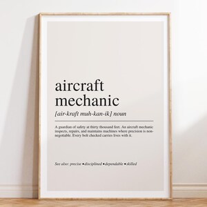 May include: A framed wall art print featuring a dictionary-style definition of the term aircraft mechanic. The text includes the phonetic pronunciation, the noun classification, and a descriptive paragraph about the profession, ending with the words see also: precise, disciplined, dependable, skilled.