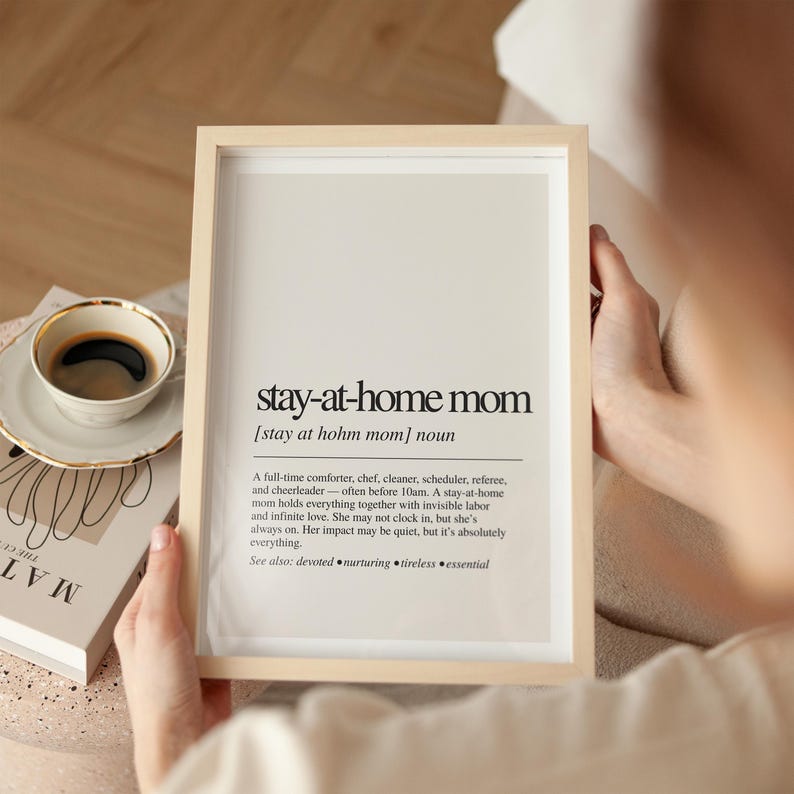 a person holding a framed book and a cup of coffee