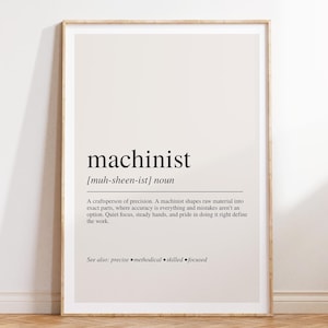 May include: A framed wall print featuring a dictionary-style definition of the word machinist. The text includes the phonetic pronunciation, the noun classification, and a descriptive paragraph about precision work, ending with see also: precise, methodical, skilled, focused.