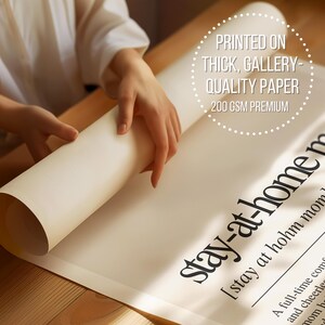 a person holding a roll of paper on top of a table
