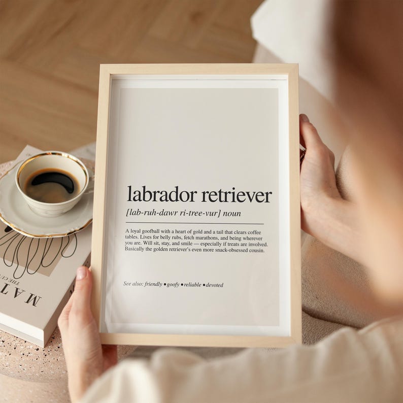 a person holding a framed poster with a cup of coffee