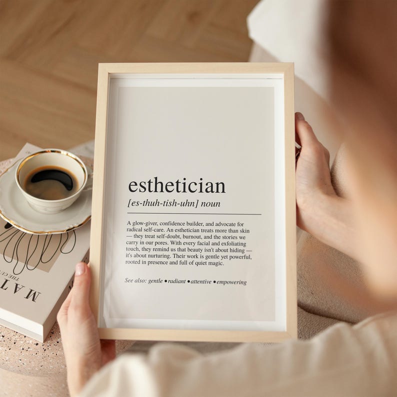 a person holding a framed book and a cup of coffee