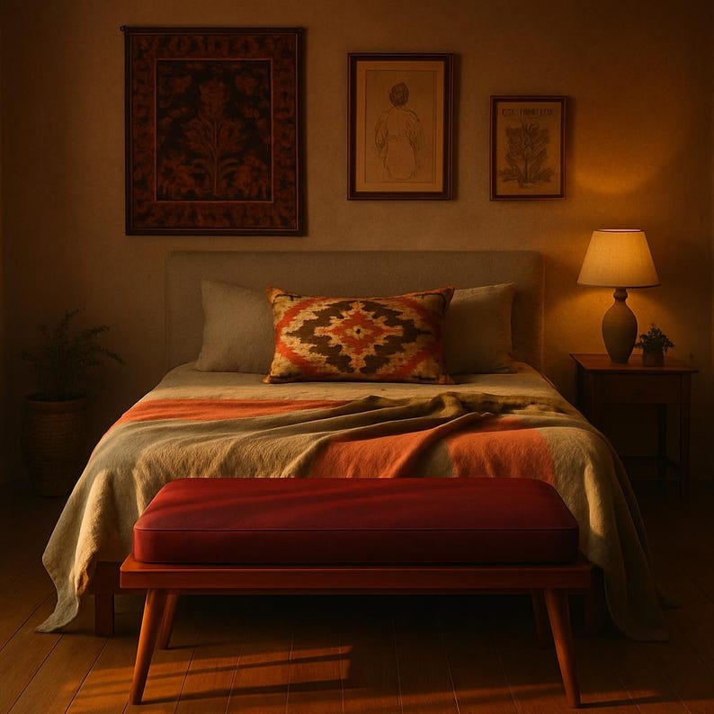 Puede incluir: Un dormitorio con una cama con una manta roja y beige, un banco de madera al pie de la cama y una l&aacute;mpara en una mesita de noche.