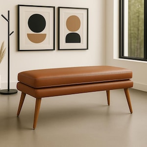 以下が含まれることがあります： 長方形の座面と丸みを帯びた角を持つ茶色の革製ベンチ。 ベンチには明るい茶色のトリムがあり、4本の角度の付いた木製の脚の上にあります。 ベンチの長さは約122cmです。