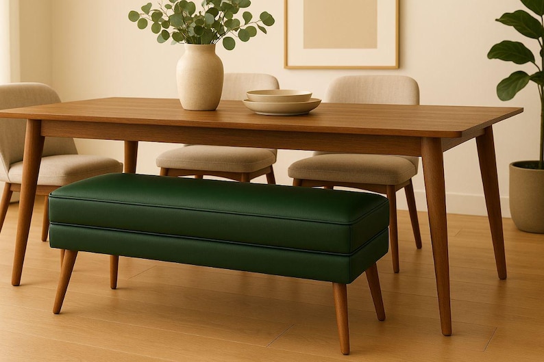 May include: A wooden dining table with four chairs and a green bench. A vase with greenery and two bowls are on the table. The chairs and bench have wooden legs. The room has a neutral color palette.